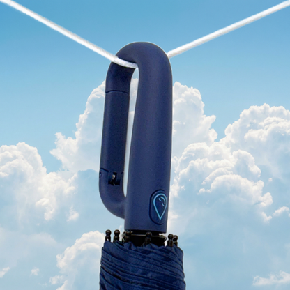 Navy clip umbrella handle against a blue sky with clouds