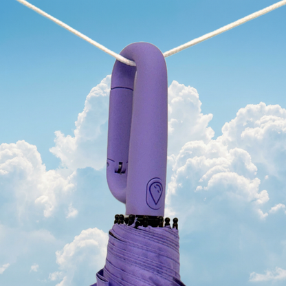 Lilac clip umbrella handle with a logo against a blue sky with clouds